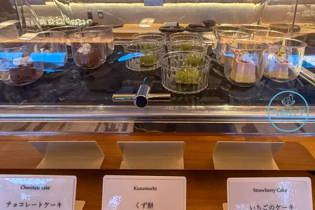 冷蔵ケースに並ぶチョコレートケーキなどの可愛らしいグラススイーツ
