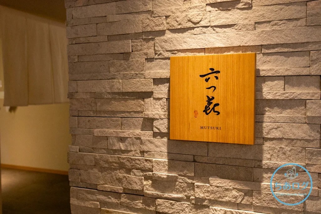 熱海・伊豆山 佳ら久 メインダイニング「六つ喜」　木の温もりと石壁が調和した上品な入り口