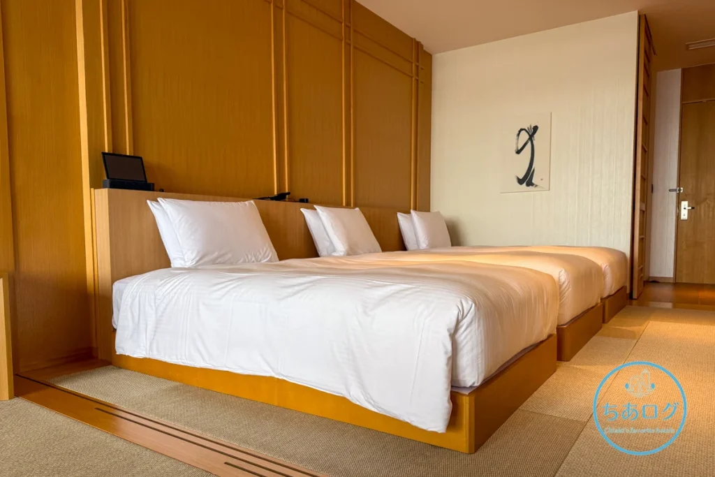 熱海パールスターホテル「デラックスオーシャンビュー VIEW BATH」トリプルルーム。和モダンの畳敷きのベッドルームに並ぶ3台のベッド。