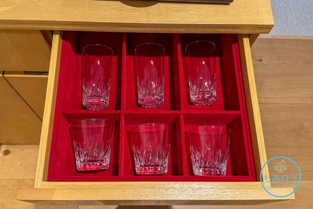 熱海パールスターホテルの赤いベルベットの引き出しに美しく並べられた、重厚なカットが入ったクリスタルのハイボールグラスとロックグラス。