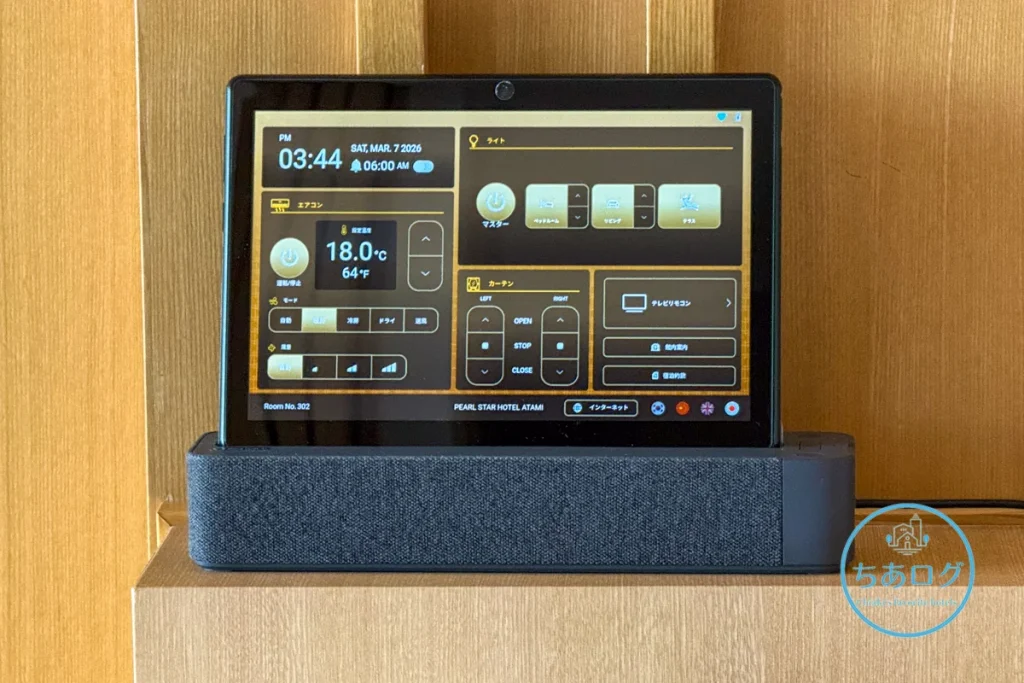 熱海パールスターホテル客室のベッド枕元に設置された、照明・エアコン・カーテン操作用のアメニティタブレット端末。
