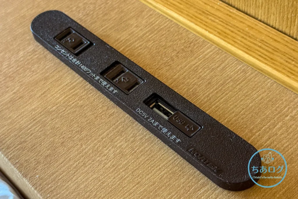 熱海パールスターホテル客室のベッド枕元に完備された、コンセント、USB Type-A、およびUSB Type-Cの充電ポート。