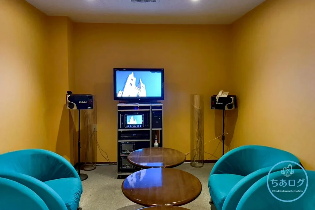 キーハイランド那須のオールインクルーシブで利用できるカラオケルーム。ブルーのソファが設置された個室。